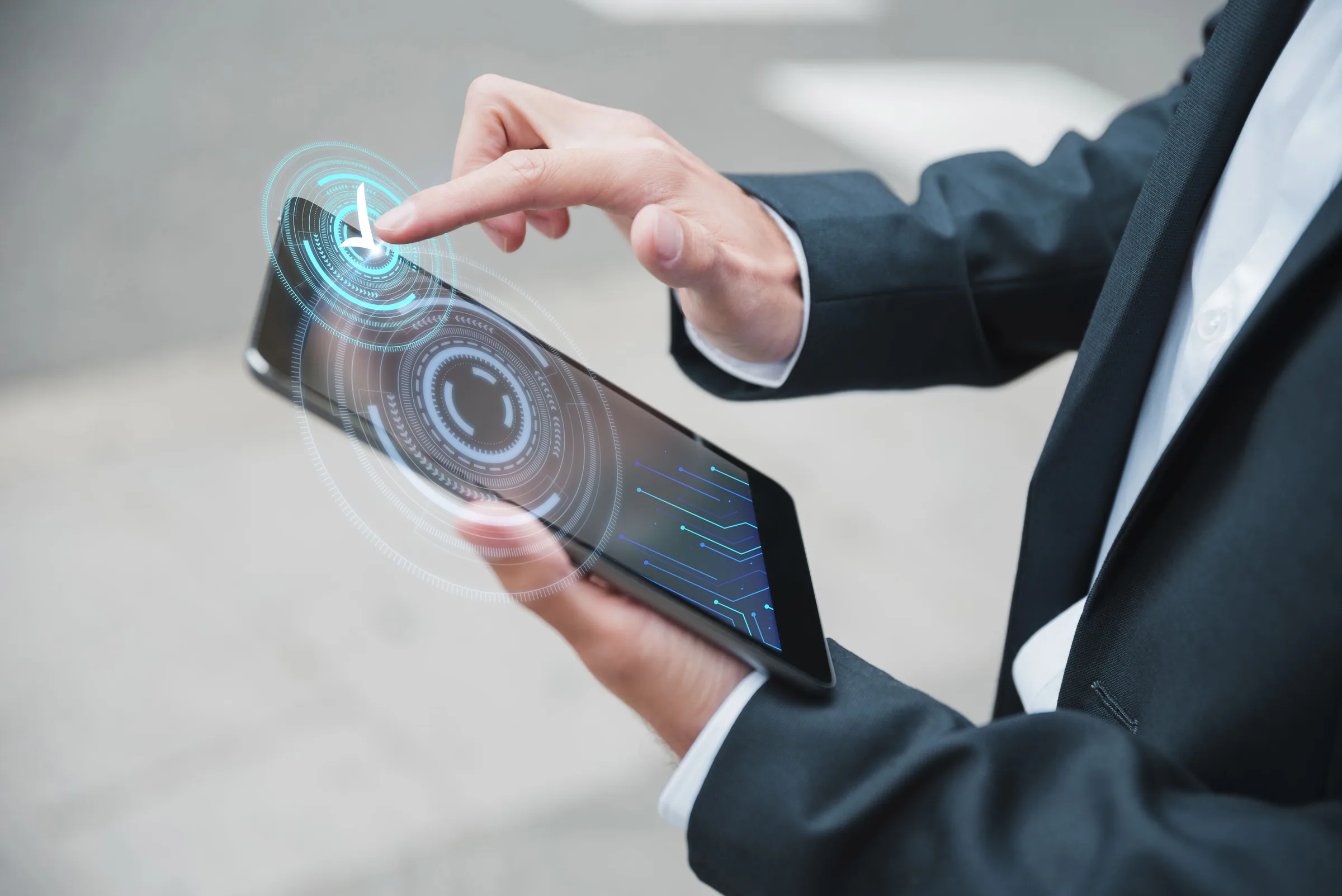 Businessman using a tablet with a futuristic digital interface representing emerging trends in digital transformation.