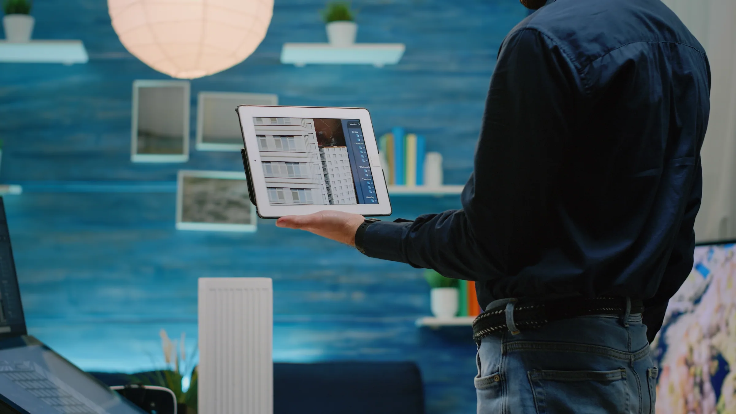 Person holding a tablet displaying intelligent automation software dashboard in a modern workspace.