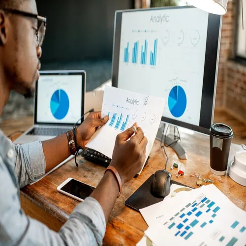 Business analyst reviewing data analytics reports, optimizing business strategy through insights.